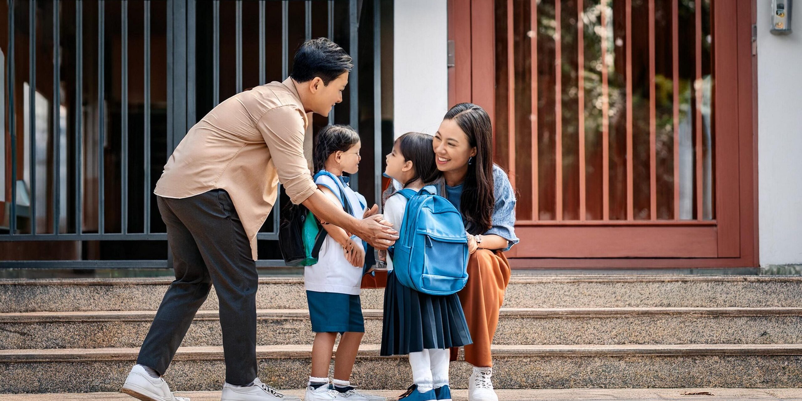 parents-dropping-off-children-school-gate-with-encouragement